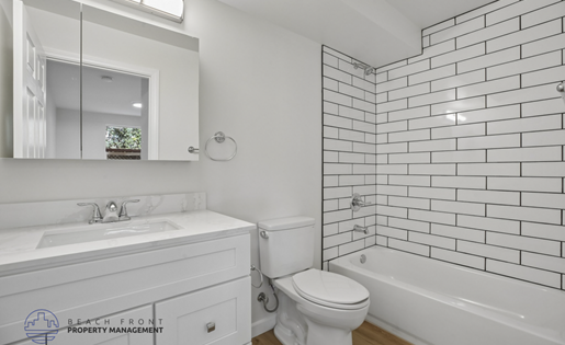 A white bathroom with a sink, toilet, and bathtub.